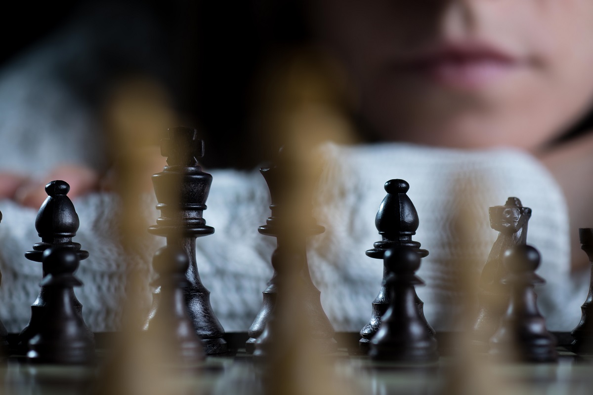 Woman playing chess thinking of next move Stock Photo - Alamy