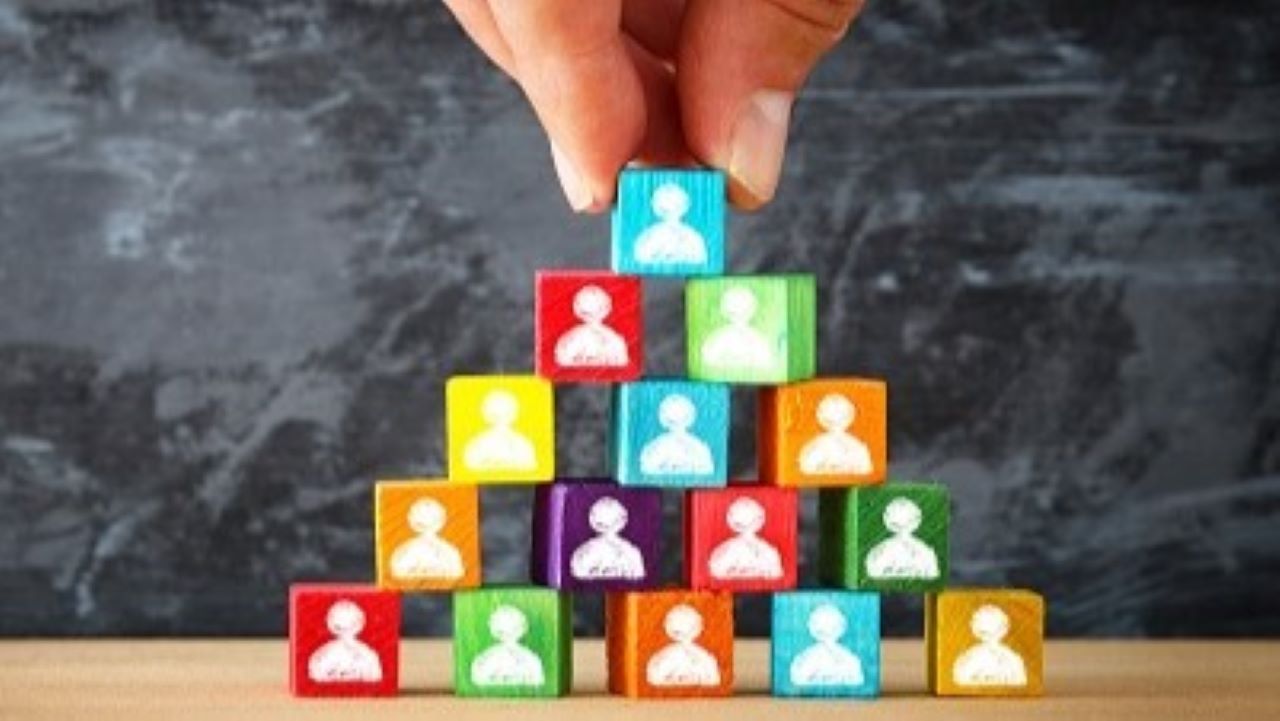 A pyramid of multi-colored blocks, each with a silhouette of a person. A pyramid of multi-colored blocks, each with a silhouette of a person.