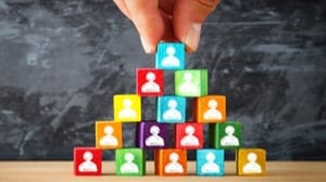 A pyramid of multi-colored blocks, each with a silhouette of a person. A pyramid of multi-colored blocks, each with a silhouette of a person.