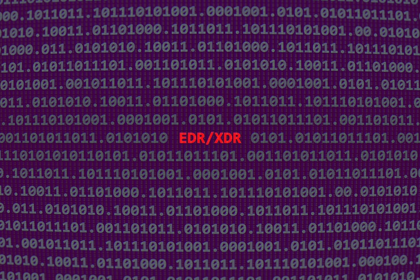simulated computer screen with random code in gray on black, then EDR/XDR in red type in center