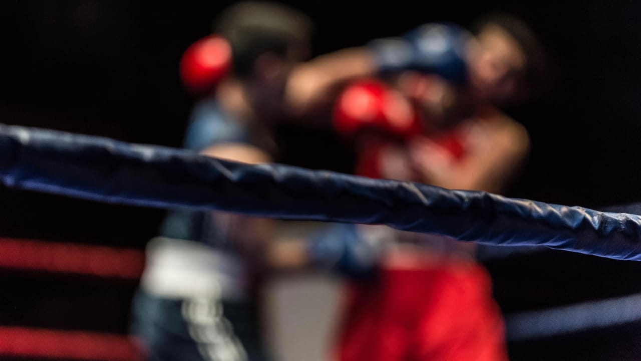 Two men boxing in the background with the ring in the forefront Two men boxing in the background with the ring in the forefront