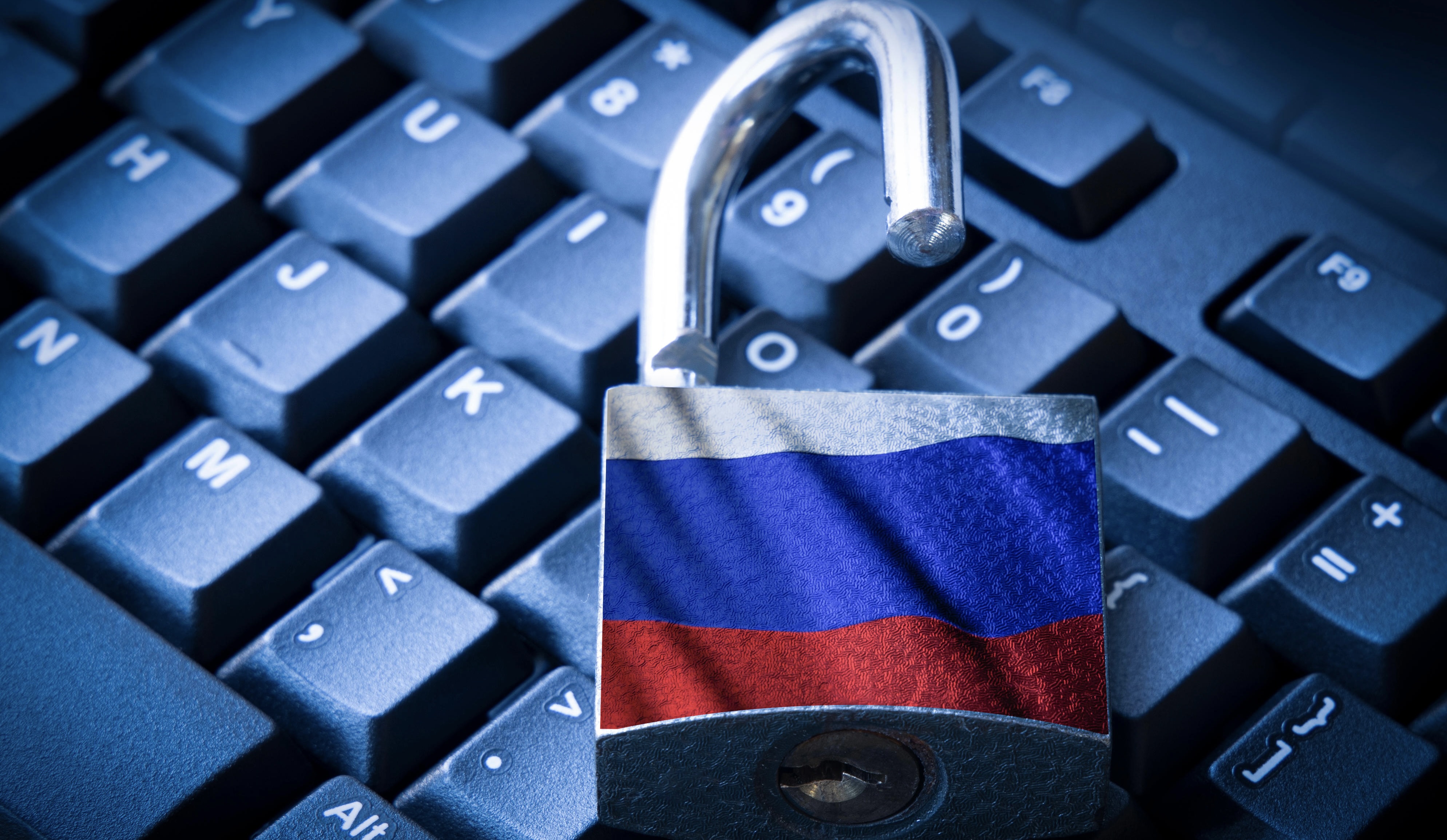 A lock with the Russian flag imprinted on it sitting atop a computer keyboard