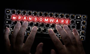 Hands typing at a keyboard on which the word "ransomware" is spelled and lit up in red