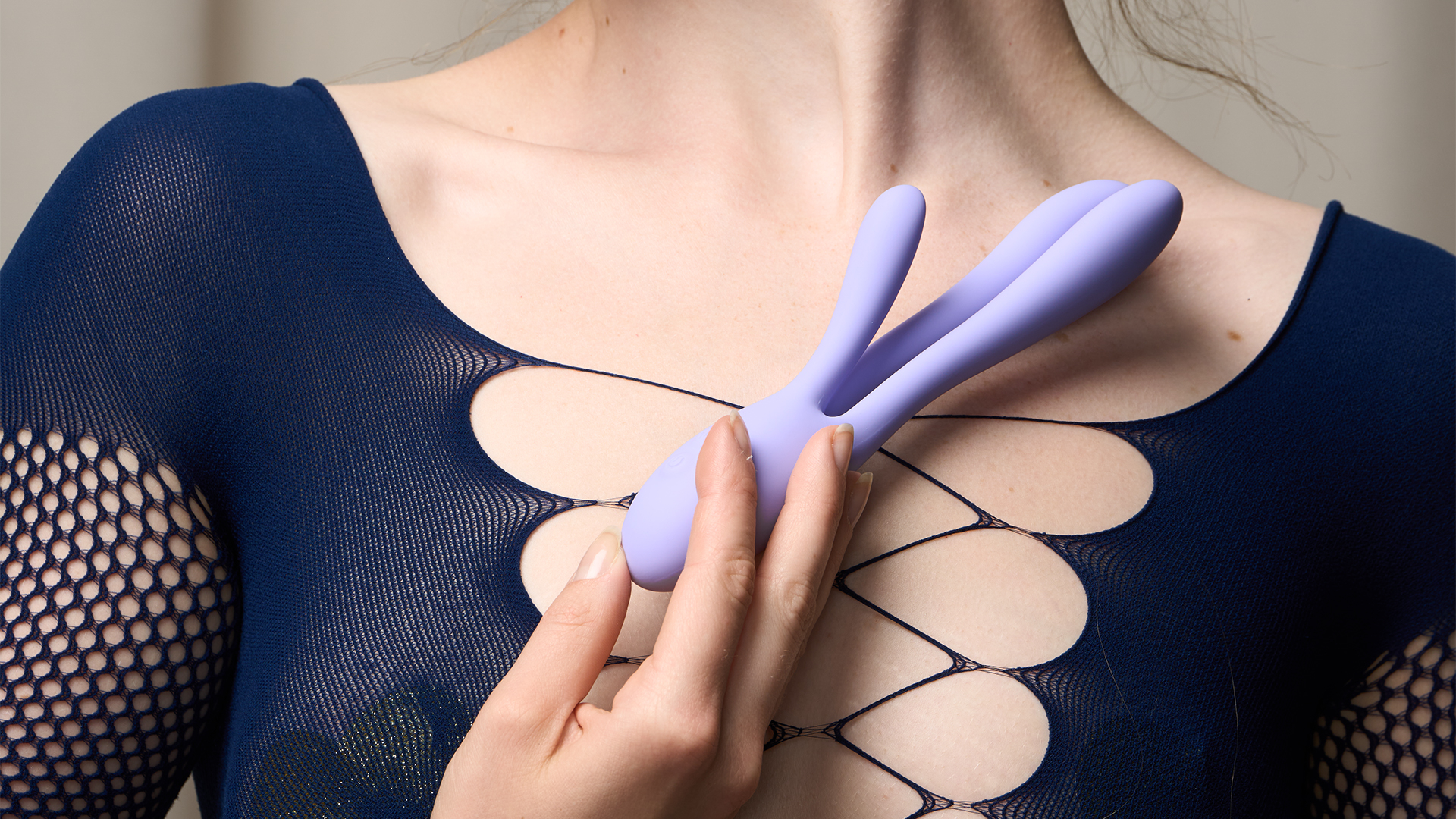En kvinna som håller en lila kaninvibrator mot bröstet