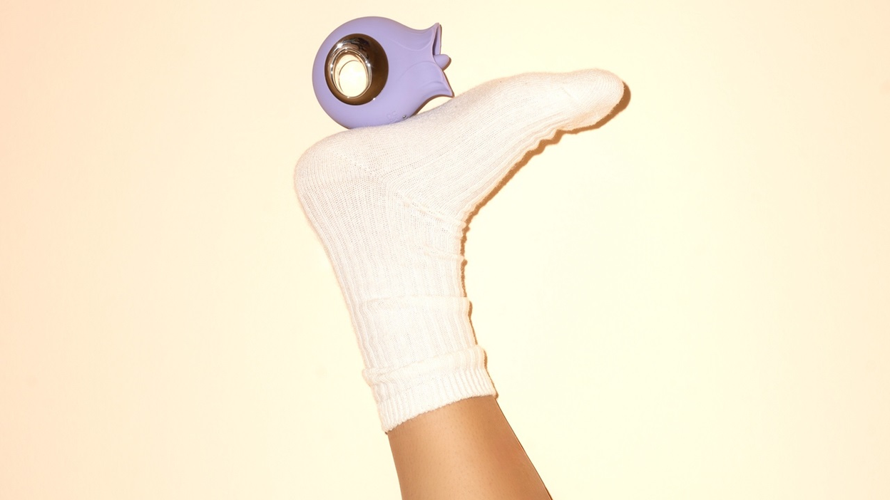 Et lilla stykke sexlegetøj, der er placeret ovenpå en fod med en hvid strømpe på