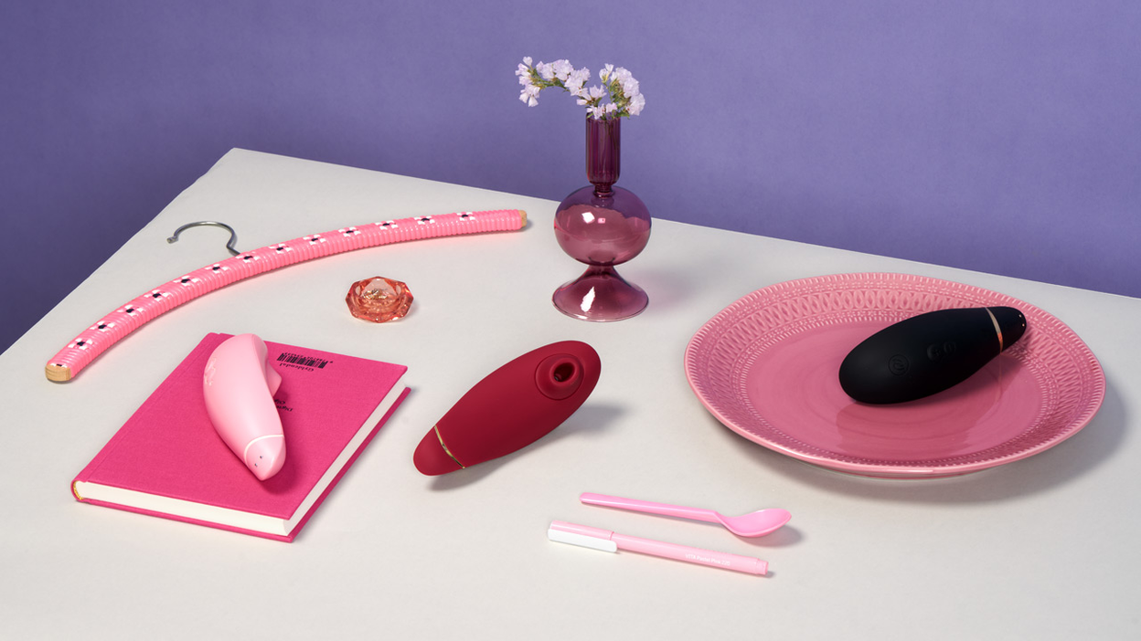 Womanizer Premium and various decorative items on a table