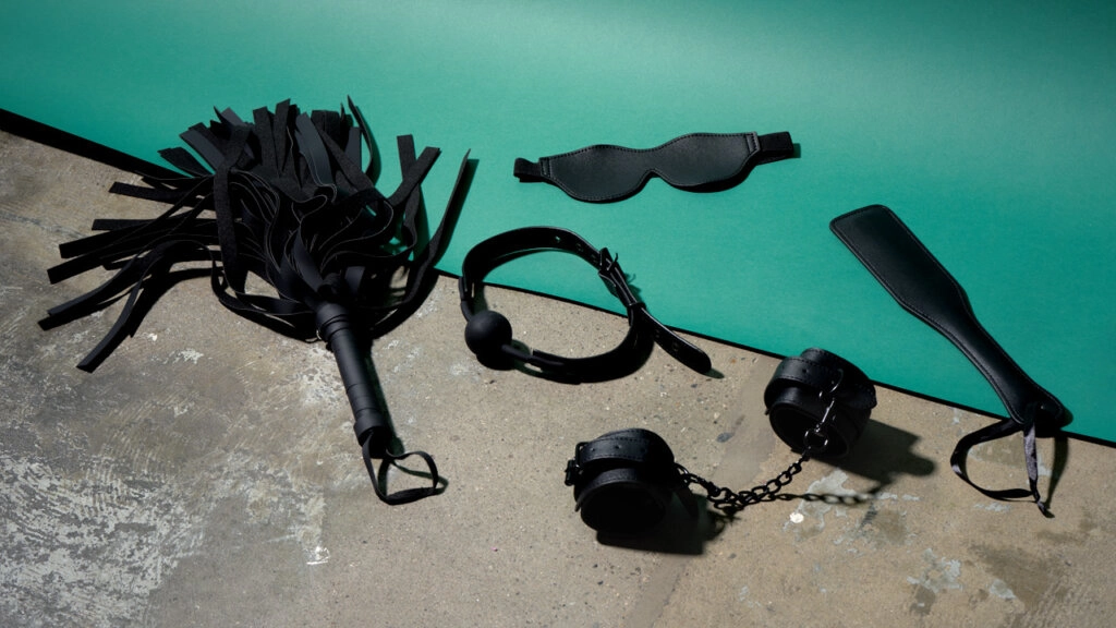 Des sextoys BDSM étalés sur le sol