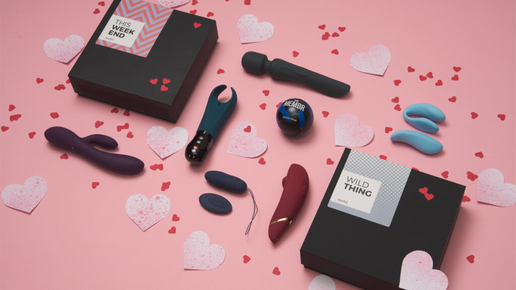 Various sex toys for women, men and couples lie together with a lot of hearts