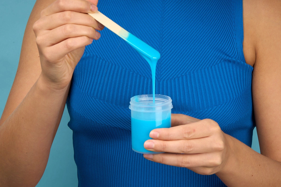 Une personne mélangeant du silicone dans un bocal