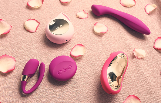 Différents sextoys LELO posés à côté de pétales de fleurs