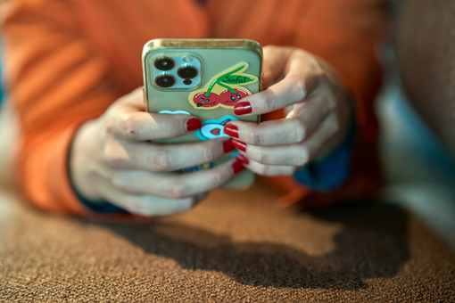 Two hands holding a phone with Sinful stickers