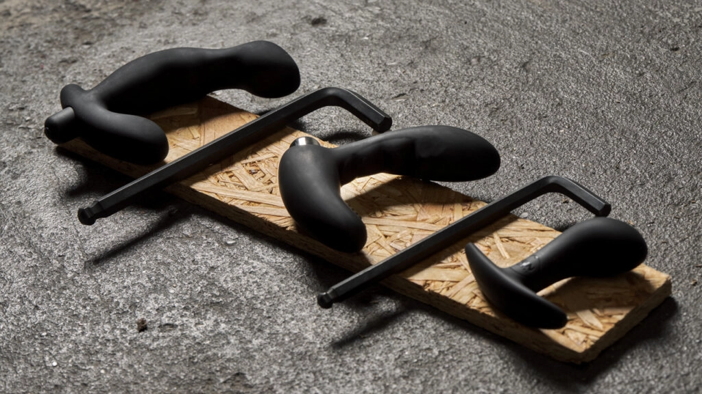 Trois stimulateurs de prostate sur une planche en bois