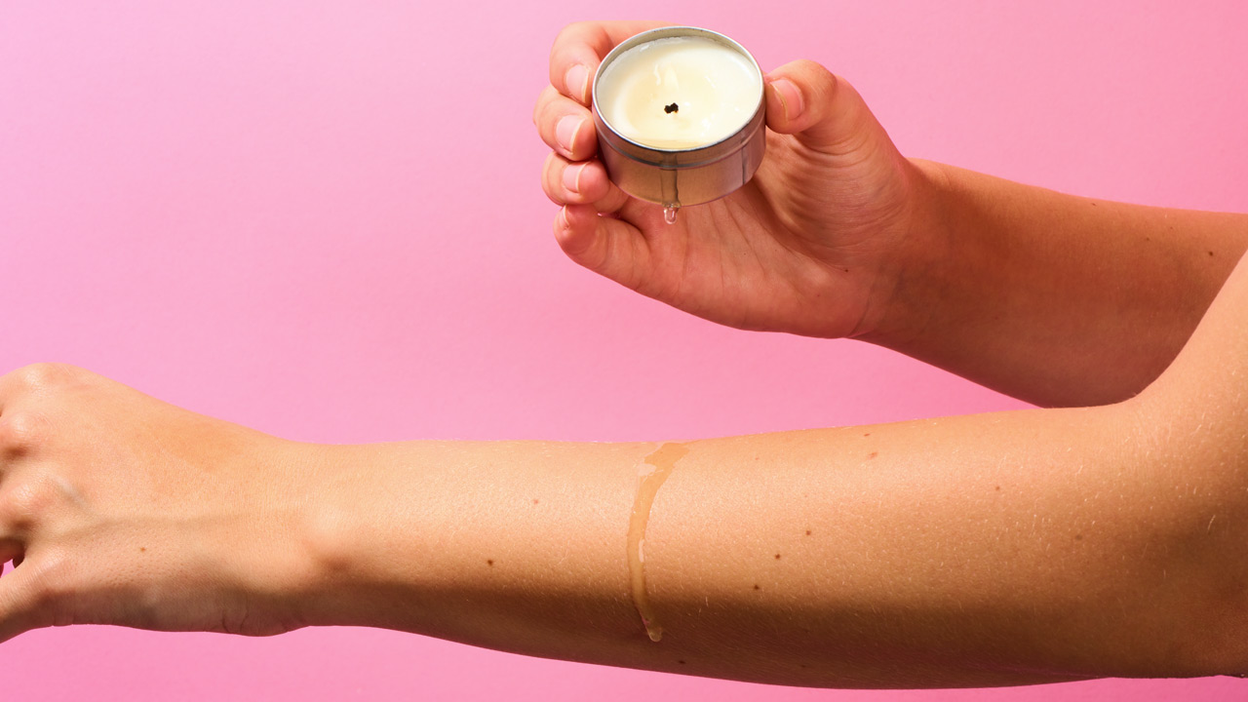 Öl von einer Massagekerze tropft auf einen Arm