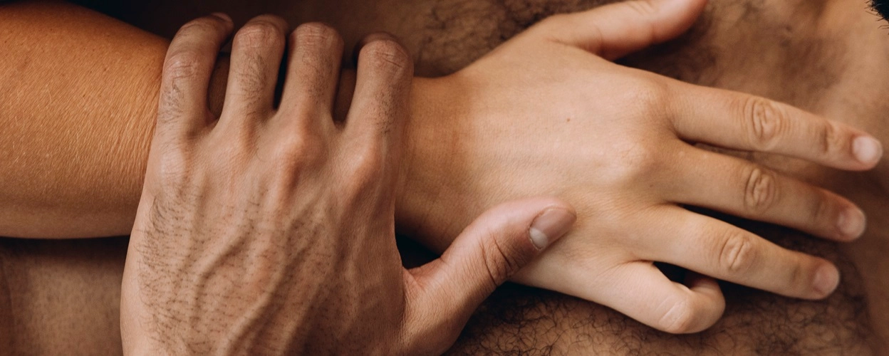 One hand resting on top of another's hand on a chest