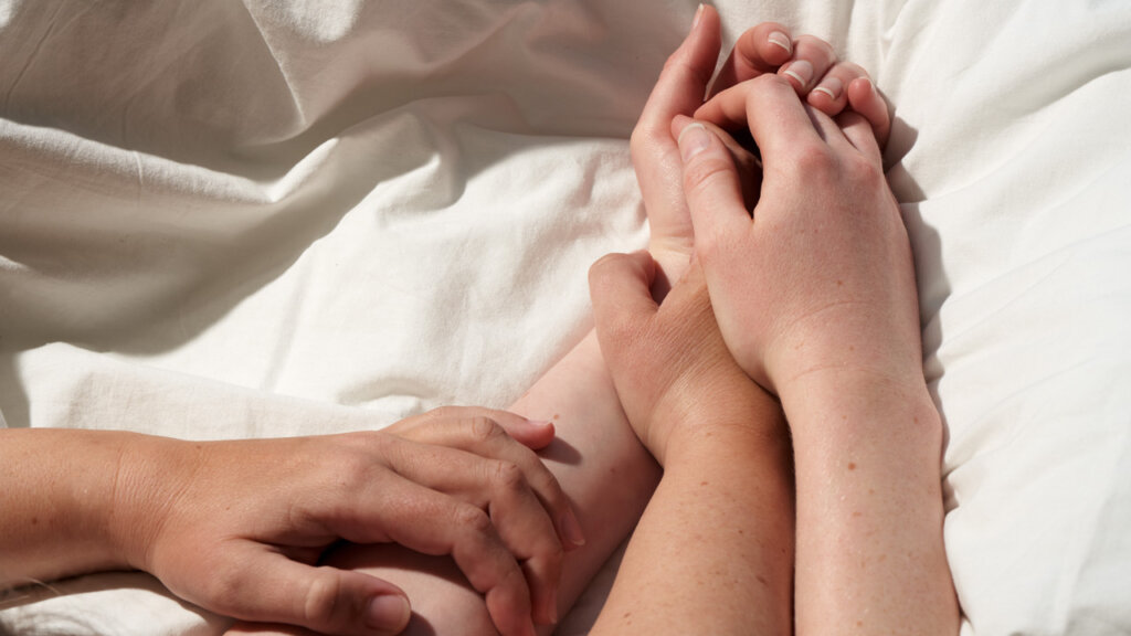 Deux personnes se tenant les mains sur un draps blanc