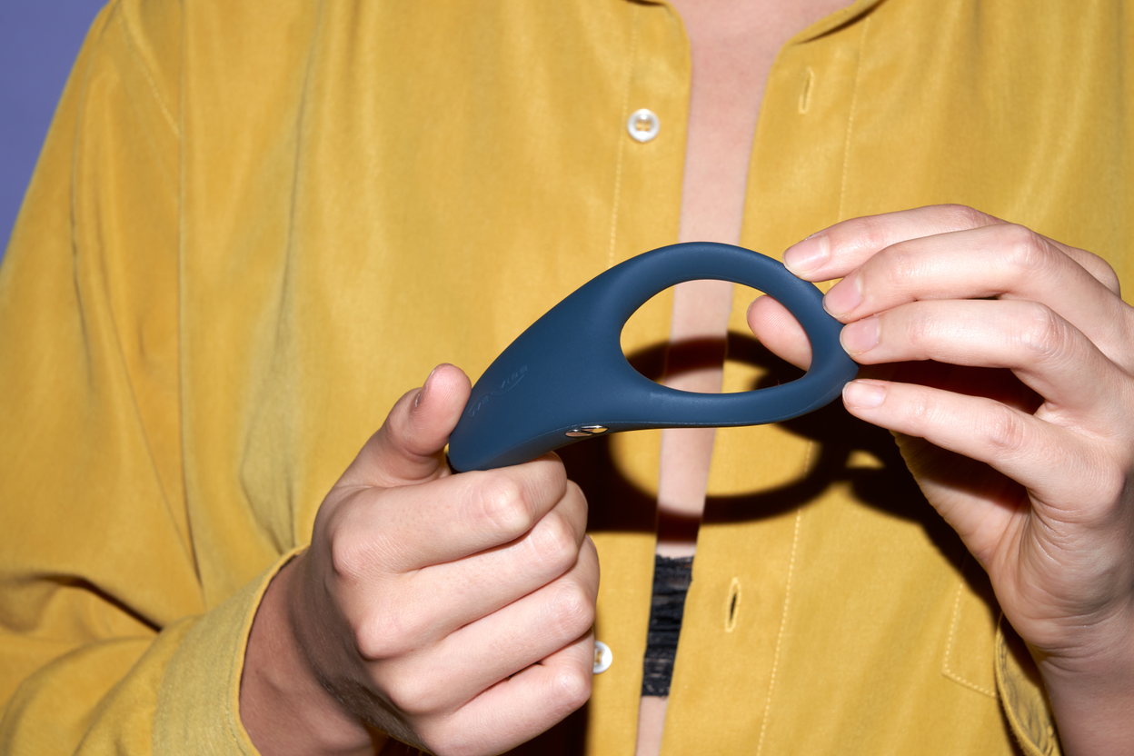 Hands holding a vibrating cock ring