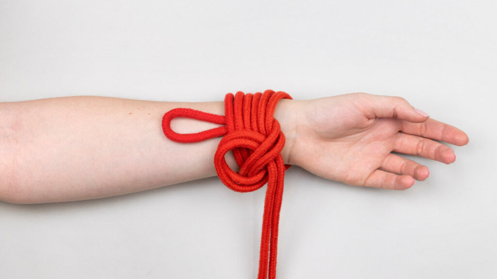 Bondage rope with a loop wrapped around a wrist