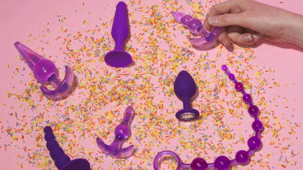 Paarse seksspeeltjes op tafel met glitter