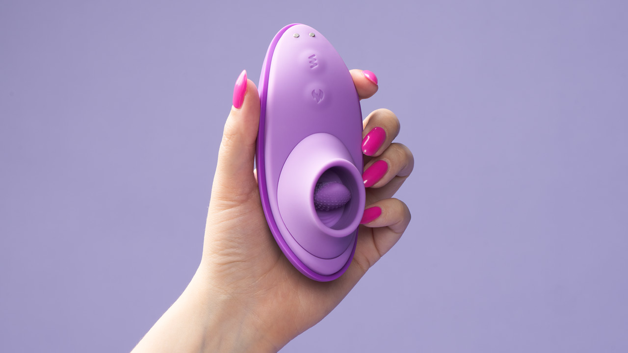 Lähikuva kädestä, joka pitelee violettia seksilelua