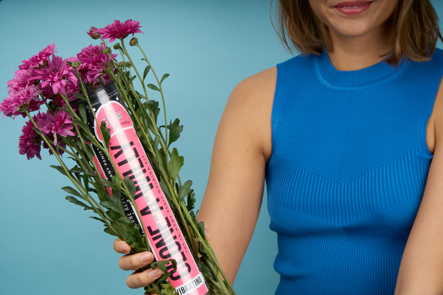Person der holder en Clone A Willy beholder med blomster rundt om