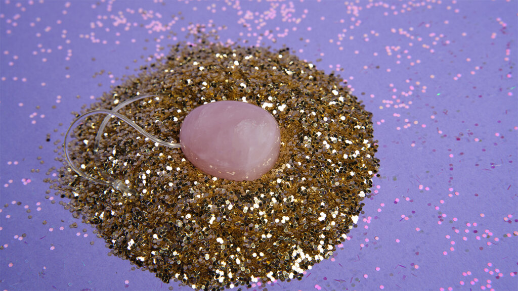 A jade egg surrounded by gold glitter
