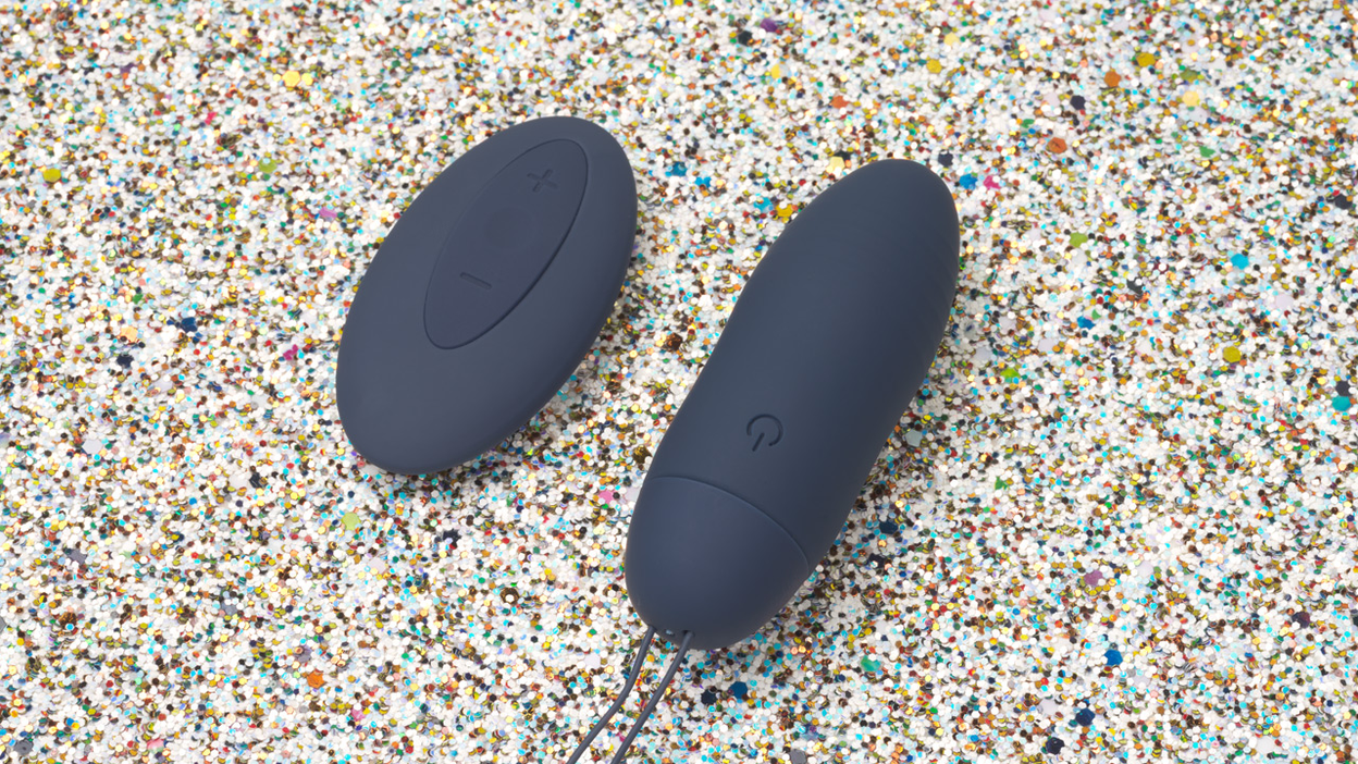 blue vibrator egg with remote control on glitter background