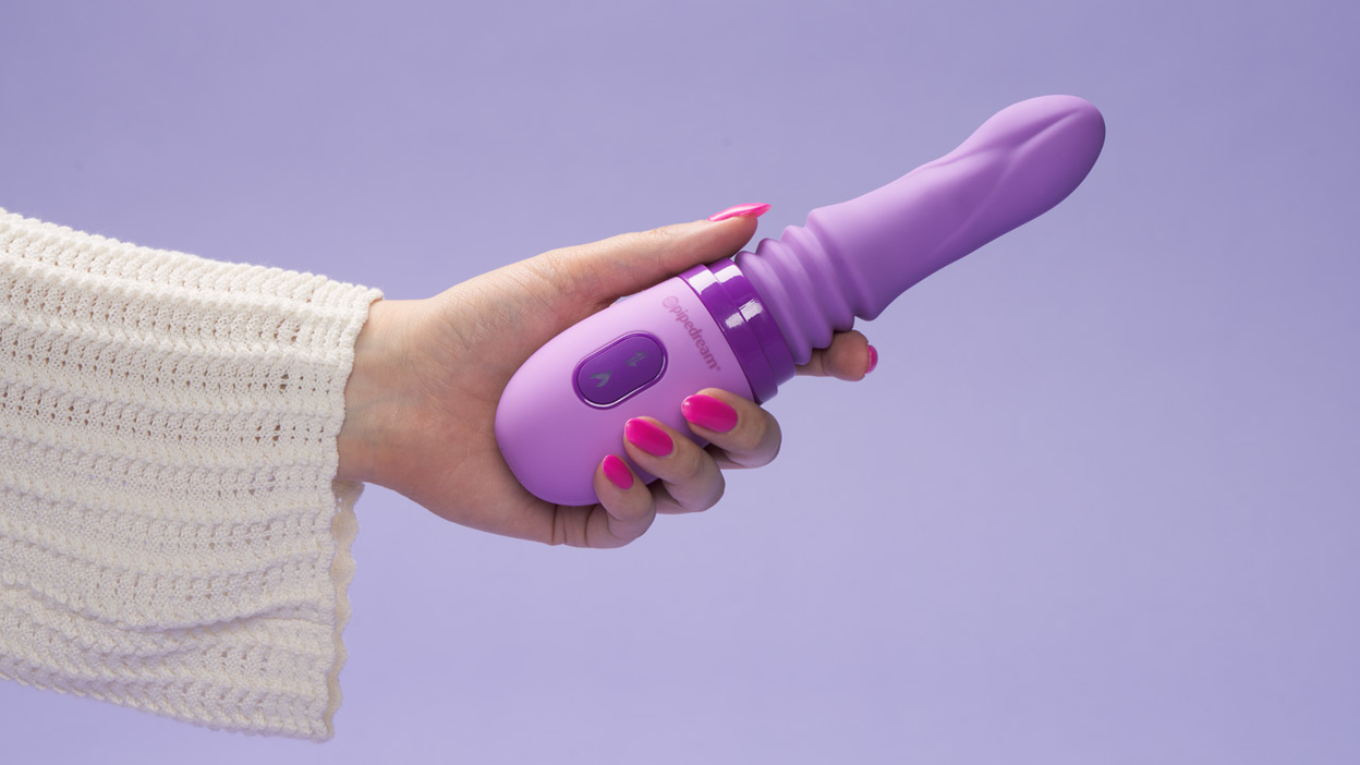 A hand holding a purple sex toy