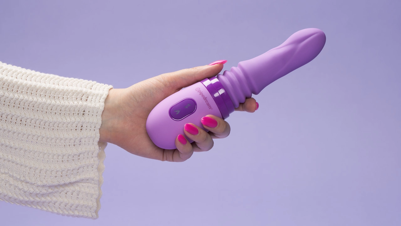 Een hand die een paars seksspeeltje vasthoudt