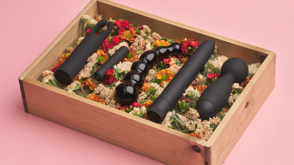 Seksspeeltjes en bloemen in een houten kist