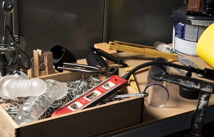 Des sextoys posés à côté d'une boîte à outils