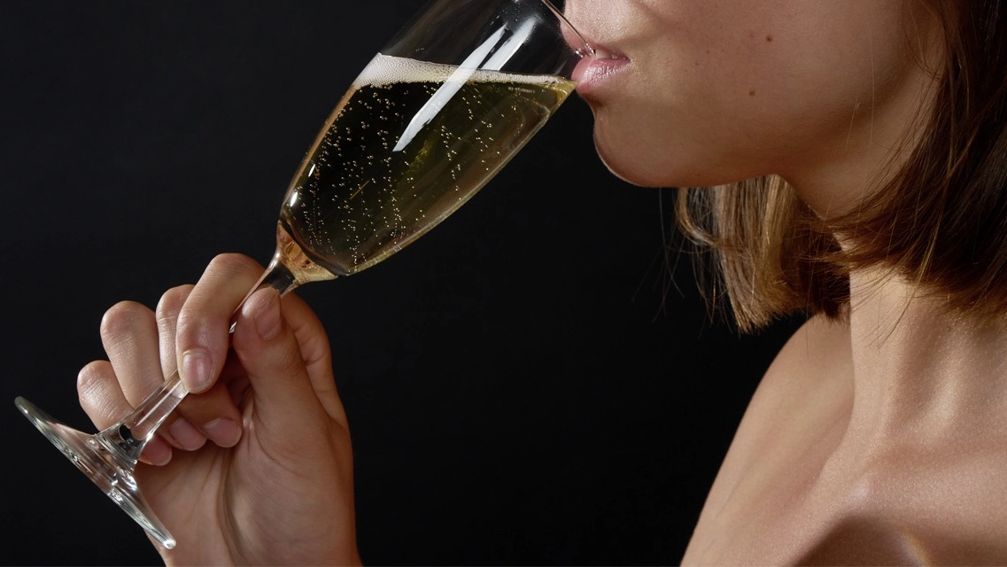 Eine Person trinkt ein Glas Champagner