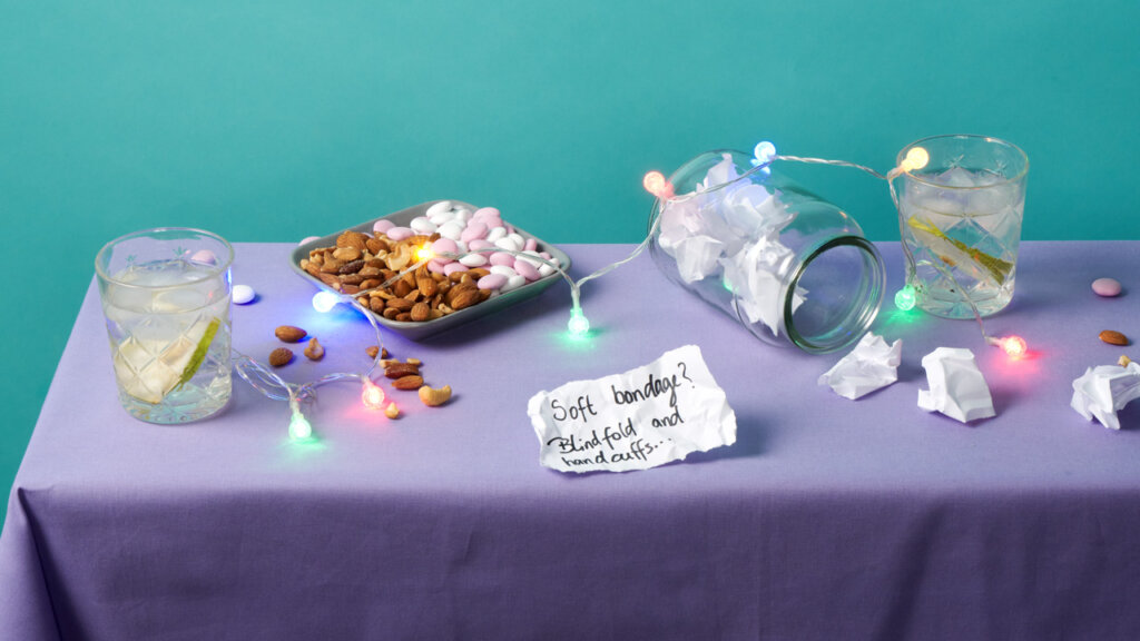 Drinker, snacks og fargerike lys på et bord med lilla duk
