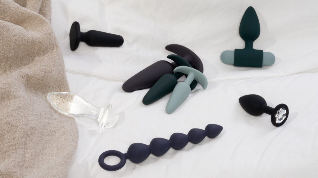 Various butt plugs lying on a bed