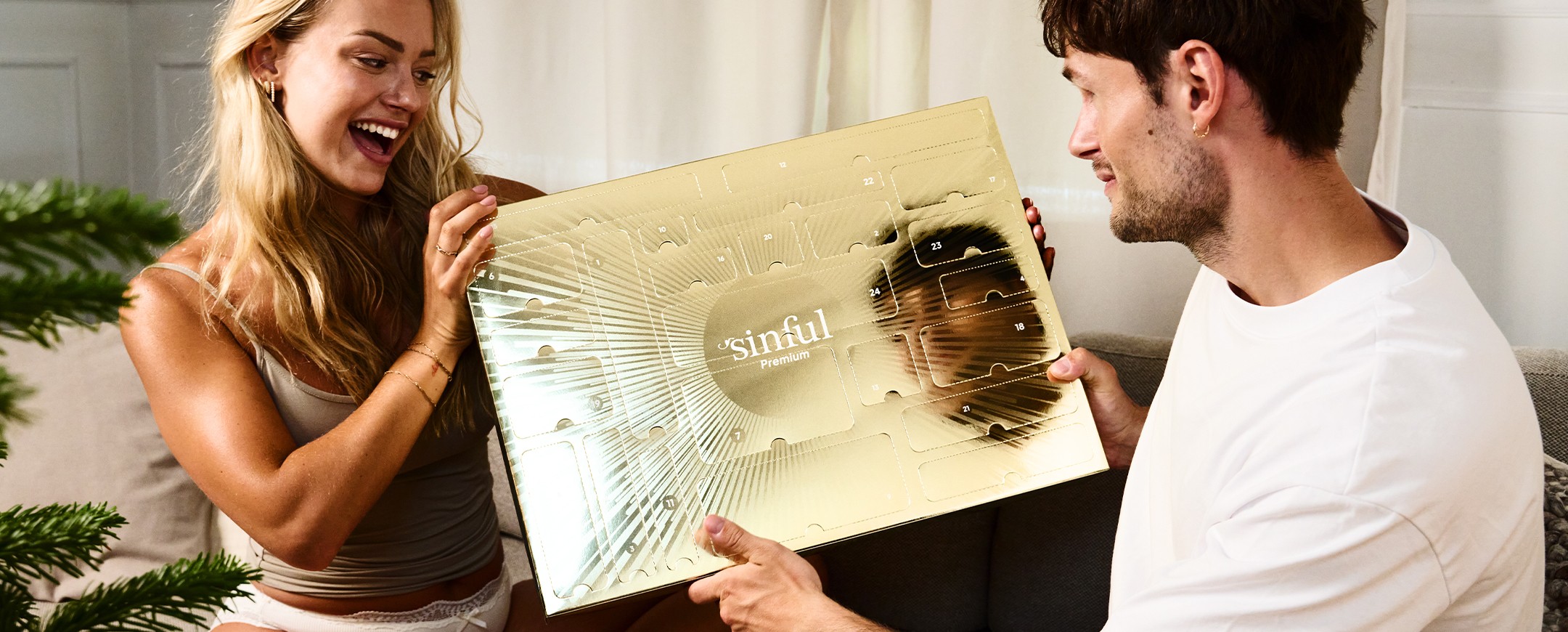 Un homme et une femme qui se regardent, avec un calendrier de l'Avent sexy Sinful entre eux