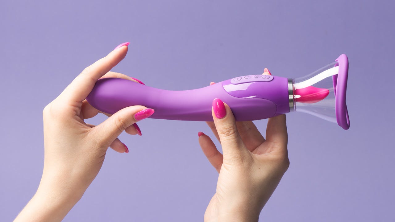 Zwei Hände halten ein lilafarbenes Sexspielzeug