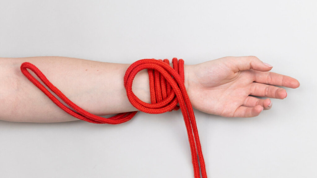 Bondage rope with a loop wrapped around a wrist