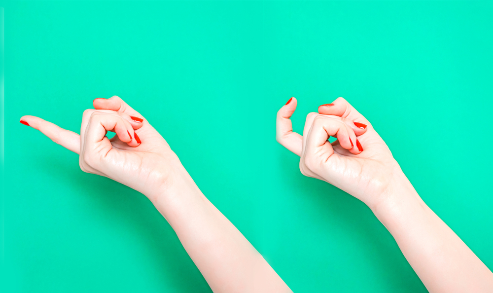To hender med rød neglelakk som gjør en kom-her-bevegelse