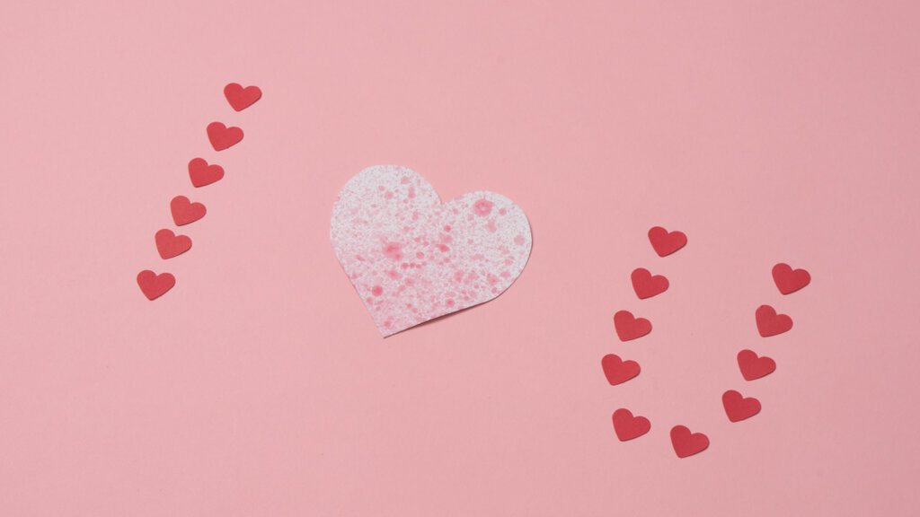"I love u" skrivet med papphjärtan på rosa bakgrund