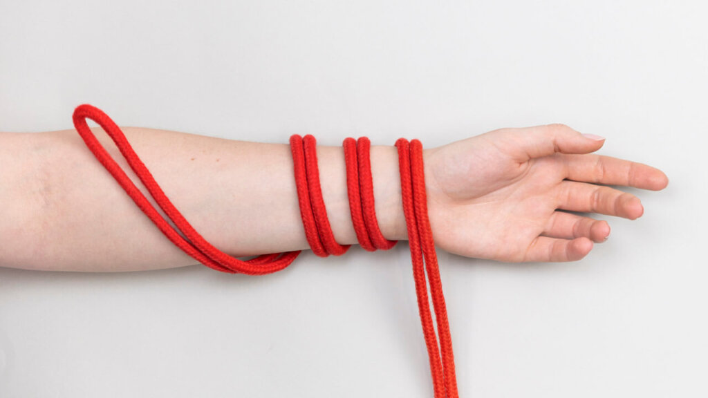 Un bras avec une corde de bondage enroulée autour
