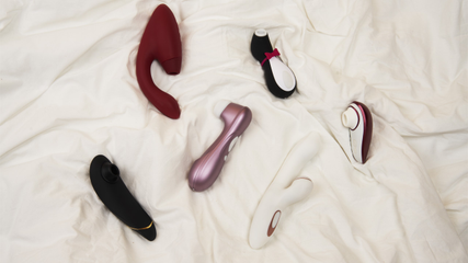 Womanizer and Satisfyer products on a bed