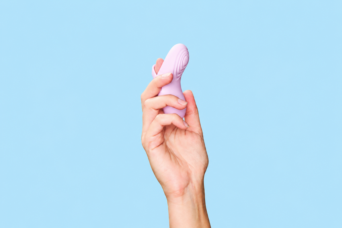En hand som håller en fingervibrator för par