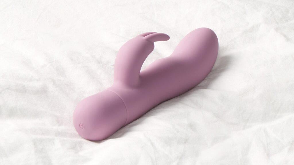 A pink rabbit vibrator lying on a duvet