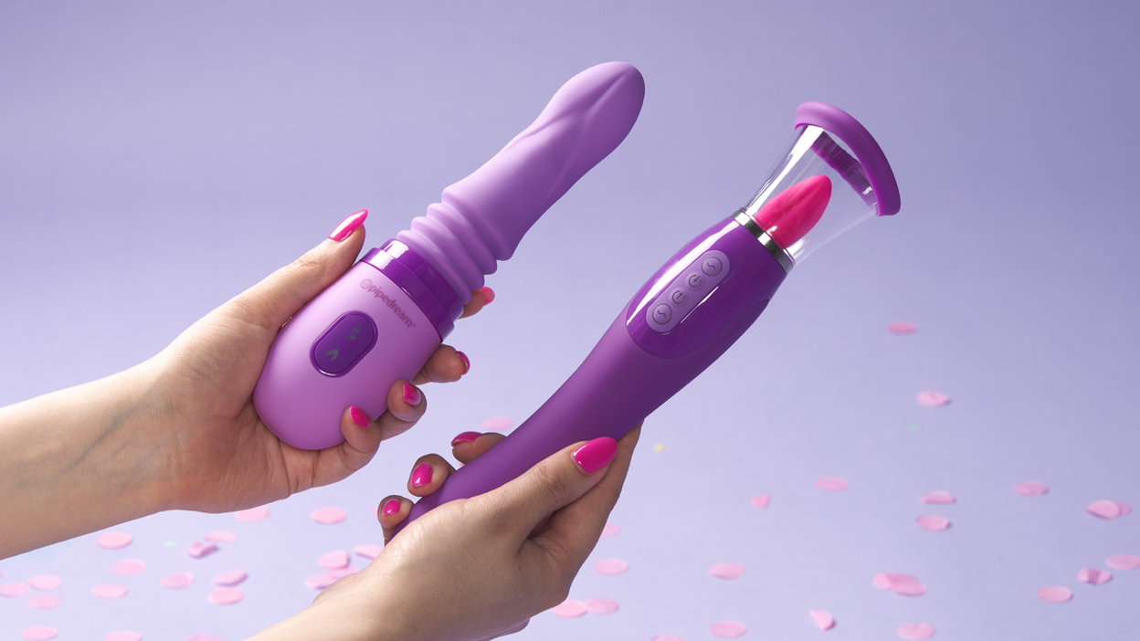 Two hands each holding a purple sex toy