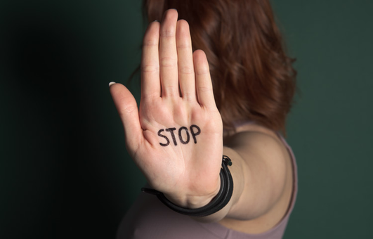 Kvinde viser sin hånd, hvor der står STOP