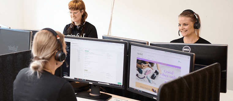 3 women working in front of screens with headsets on