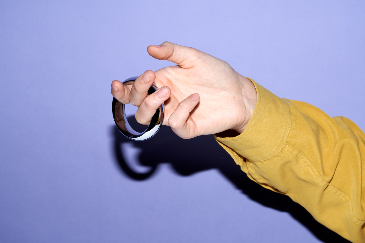 Hand holding a see-through cock ring