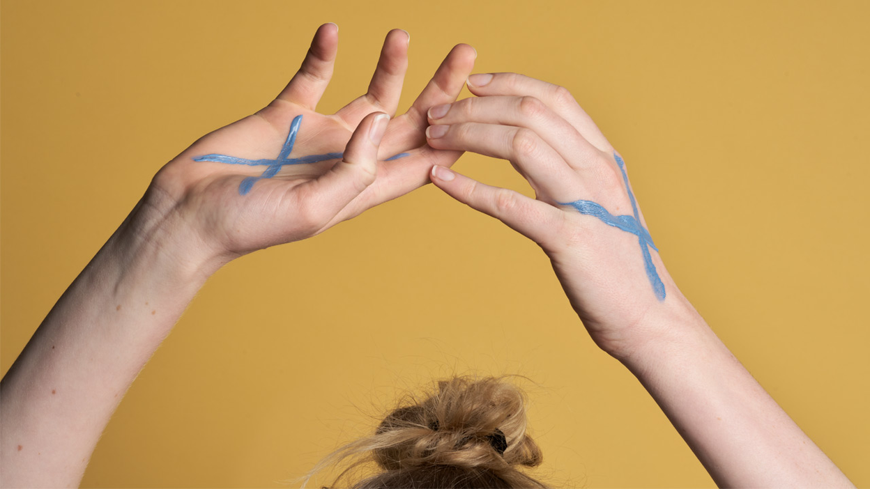 Vrouw met blauw kruis op handen