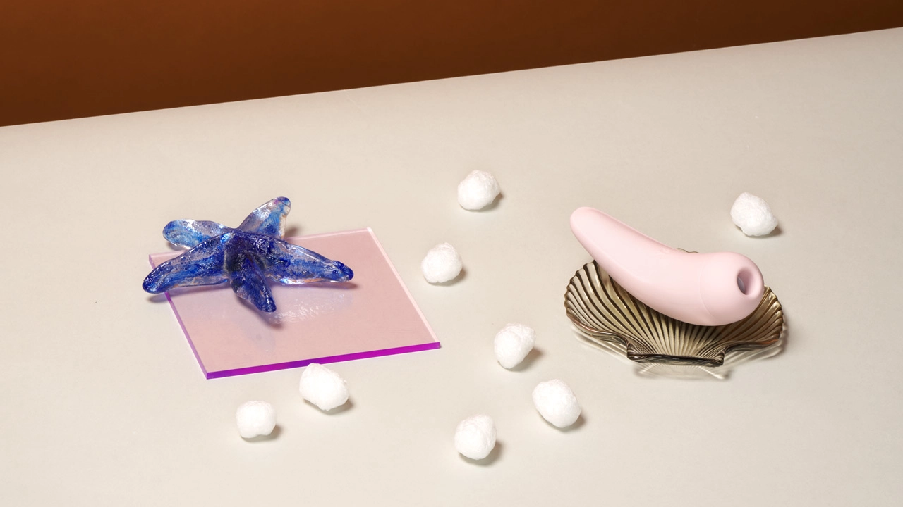 Satisfyer Curvy 2+ og forskjellige pynteting på et bord
