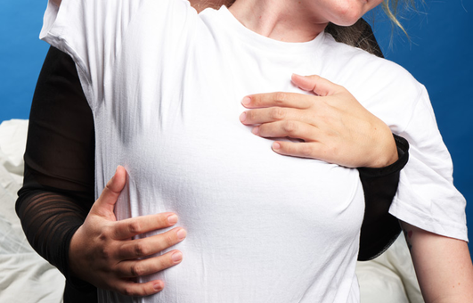 Woman in white t-shirt is held from behind