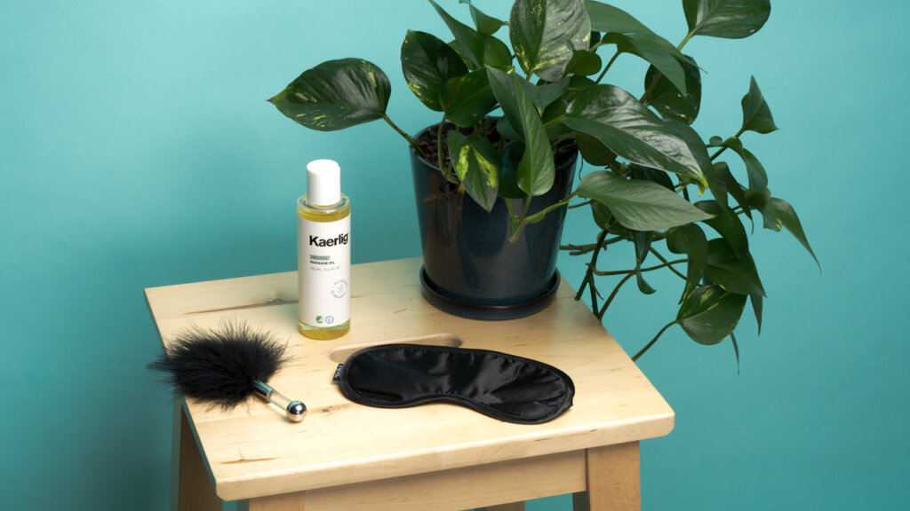 Tickling feathers, massage oil, and a blindfold on a table